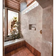 a bathroom with a shower head, window and tile flooring is pictured in this image