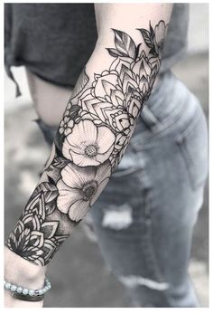 a woman's arm with flowers and leaves tattooed on the left side of her arm