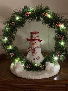 a christmas wreath with a snowman and candy canes in it on a table