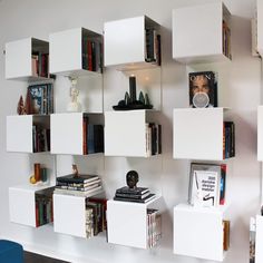 the bookshelves are stacked high on the wall