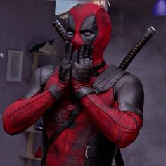 deadpool is holding two knives in his hands