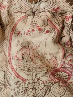 an old piece of cloth has been embroidered onto with flowers and cherubs on it