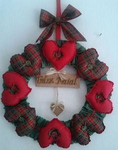 a wreath with red and green flowers hanging on the wall