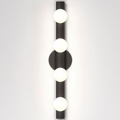 a wall mounted light with three lights on it's side and two balls in the middle