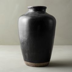 a black vase sitting on top of a white table