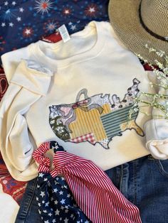 Go ahead and show off your patriotic spirit while adding your own vintage flare!  Oh and don't forget that cute little bow!   This beautifully embroidered applique United States Pullover is perfect year round, not just for a holiday.   Completely reminding you of your favorite quilt from Grandma's house!   The quilted vintage looking fabric is adorable and classic!   These are unisex fit, if you are looking for an oversized look please size up.   **This fabric varies in pattern and placement dur Usa Quilt, Applique Sweatshirt, Greenville Nc, Grandma's House, Vintage Flare, Quilted Pattern, Vintage Quilt, Grandmas House, Embroidered Applique