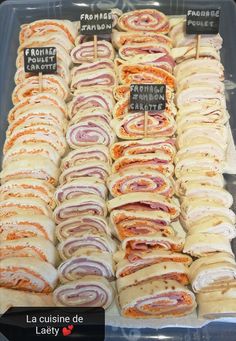 many different types of sandwiches on display in a plastic container with labels for each item