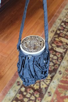 a blue purse hanging from the side of a wooden floor in front of a rug