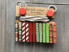 a bunch of different colored paper and rope on top of a wooden board with a tag