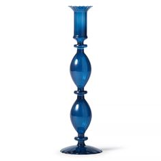 a tall blue glass vase sitting on top of a table