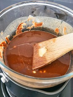 a wooden spatula in a glass bowl filled with melted chocolate