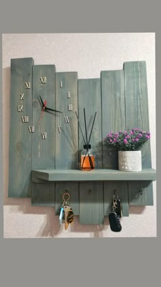 a clock mounted to the side of a wooden wall next to key holders and flowers