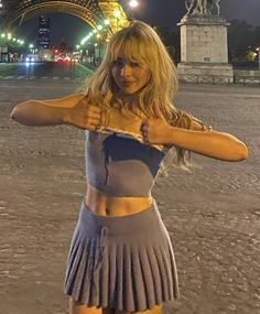 a woman posing in front of the eiffel tower with her hand on her hip