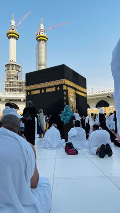 many people sitting on the ground in front of a building