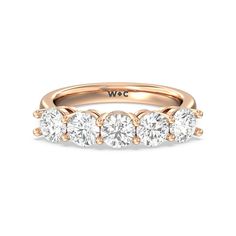 a yellow gold ring with five round diamonds