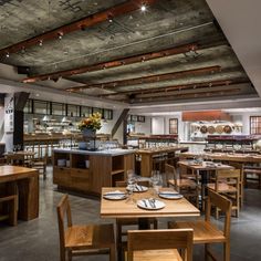 an empty restaurant with wooden tables and chairs