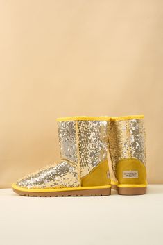 Spice up your shoe game with Smaibulun Ugg's Dallas Glam Sequin Shearling Boots! The perfect blend of style and comfort, these boots feature playful yellow glam sequins and cozy shearling lining. Who says ugg footwear has to be boring? (No one, that's who!) 1'' heel 7.6'' shaft 15.8'' circumference Pull-on Suede upper & Man-made sequins Faux fur lining EVA sole