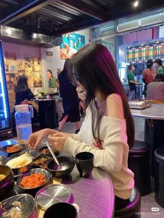 a woman sitting at a table with food in front of her