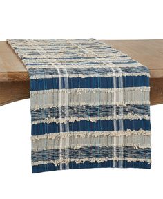 a blue and white table runner on top of a wooden bench