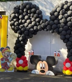 mickey mouse balloons are arranged in front of a wall