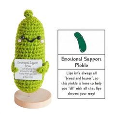 a crocheted pickle is holding a sign that says,'emotion support pickle '