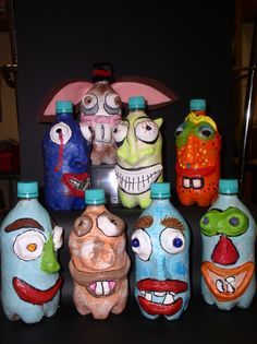 five painted bottles with faces on them sitting next to each other