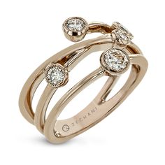 a rose gold ring with three diamonds on the top and two smaller stones in the middle