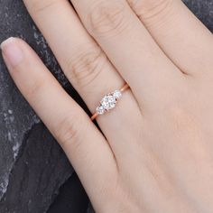 a woman's hand with a diamond ring on top of her finger and the other hand holding it