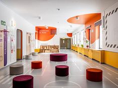 an empty room with several stools on the floor and colorful walls in the background