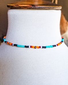 a white mannequin wearing a multicolored beaded necklace on it's neck