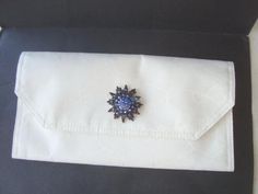 a black and white box with a blue brooch in it's lapel