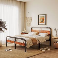 a bed room with a neatly made bed next to a window and a potted plant