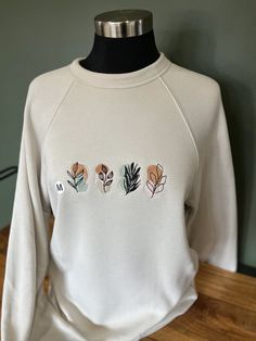 This sweatshirt blends premium quality with a charming design featuring intricate boho-inspired plants (6.8 x 2.4 in), ideal for bohemian style enthusiasts or anyone who loves artistic apparel. If the item is out of stock in the desired size, please reach out and we can provide information regarding time required to restocking. Additionally, if you would like a different color/design, please see our listing for customized orders. Embroidery design file was purchased for license use from ThelabelsCo (more information at https://www.etsy.com/listing/1311340281/commercial-use-license-unlimited-use-for?click_key=633bc425ba2f9250ab277d8c2e26b16662355c10%3A1311340281&click_sum=668e0fd0&ref=shop_home_feat_2). Sweatshirt is of the highest quality, made in America by Bella+Canvas (color: Heather Du Spring Bohemian Cotton Sweatshirt, Bohemian Crew Neck Sweatshirt For Fall, Bohemian Relaxed Fit Sweatshirt For Fall, Botanical Style Cotton Sweatshirt For Fall, Bohemian Cotton Sweater With Relaxed Fit, Bohemian Cotton Sweater Relaxed Fit, Bohemian Cotton Sweater In Relaxed Fit, Bohemian Long Sleeve Sweatshirt With Relaxed Fit, Bohemian Relaxed Fit Cotton Sweater