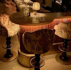 an elegantly decorated table and chairs in a fancy restaurant with wine glasses on it