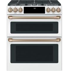 a white and gold stove with two ovens on each side, one is built into the wall