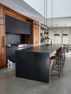 a kitchen with black counter tops and stools next to an island in the middle