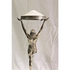 a silver statue holding a tray on top of it's head and arms in the air