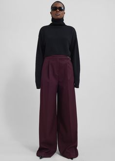 Color: Burgundy Midweight woven fabric Regular fit Wide leg Mid-rise Belt loops Side seam pockets Back illusion welt pockets Zip fly Asymmetric front button closure Unlined 77% Polyester 21% Rayon 2% Elastane Dry Clean By The Frankie Shop. Imported Dark Red Pants Outfit, Burgundy Trousers Outfit, Edgy Business Casual, Maroon Pants Outfit, Red Pants Outfit, Burgundy Trousers, Cropped Turtleneck Sweater, Maroon Pants, Cropped Turtleneck