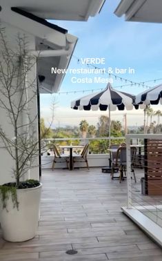 an outdoor restaurant with tables and umbrellas on the roof terrace, overlooking the ocean