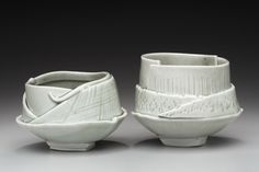 two white ceramic bowls with designs on them