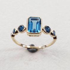 **KINDLY CHECK OUT THE VIDEO OF THE ITEM FOR A CLEARER VIEW**Details of the ring Gemstone: Center Gem: London blue topaz Side Gem: Blue Diamond Gemstone shape: Center Gem: Octagon 7×5 mm Side Gems: Round 3 mm (2pec) Round 2.5 mm (2 pec) Round 2.0 mm (2 pec) Total gemstone weight: 1.69 carats Metal: GOLD Purity: 14 KT Weight: 1.56 Grams Total weight of the ring: 1.90 grams Ring size us 6 Beautiful emerald cut london blue topaz with rich deep blue diamond color set in 14kt Gold, a perfect gift for Fine Jewelry Multi-stone Blue Topaz Ring, Fine Jewelry Blue Topaz Birthstone Ring With Gemstone Accents, Blue Topaz Birthstone Ring With Gemstone Accents, Modern Topaz Ring With Gemstone Accents For Anniversary, Blue Topaz Ring With Emerald Cut And Bezel Setting, Blue Multi-stone Birthstone Ring In 14k Gold, Blue Multi-stone 14k Gold Birthstone Ring, 14k Gold Blue Multi-stone Birthstone Ring, Blue Multi-stone Topaz Ring For Gift