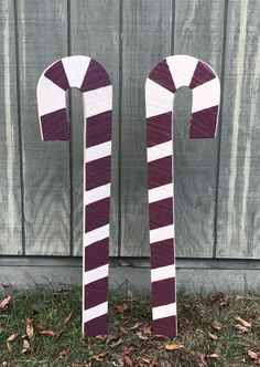 two wooden candy canes sitting in the grass