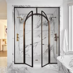 a marble bathroom with an arched shower door