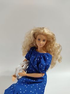 a blonde doll in a blue dress with white polka dots on it's body