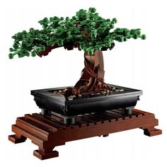 a lego model of a bonsai tree on a pallet with rocks and wood