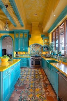 a kitchen with blue cabinets and yellow counter tops, painted in turquoise and orange colors