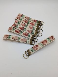 four red and green christmas trees on white fabric key fobs with metal clips