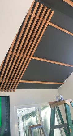 an unfinished ceiling with wooden slats hanging from it's sides and ladders