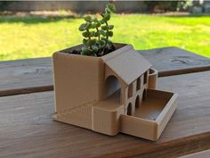 a house shaped planter sitting on top of a wooden table