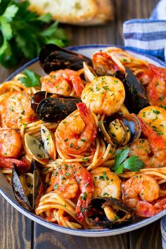 seafood pasta with clams and mussels in a skillet on a wooden table